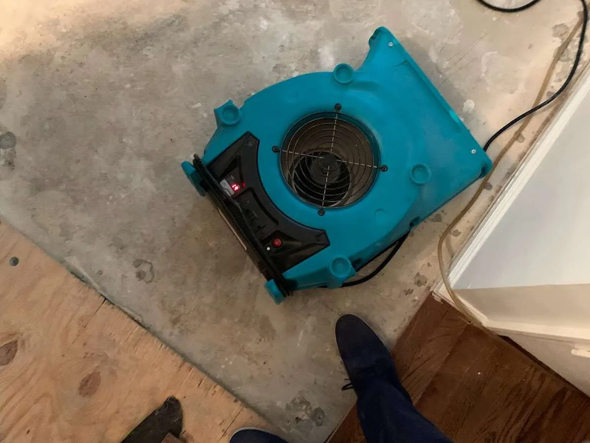 Air mover drying subfloor during Commercial Water Damage Restoration in Columbus